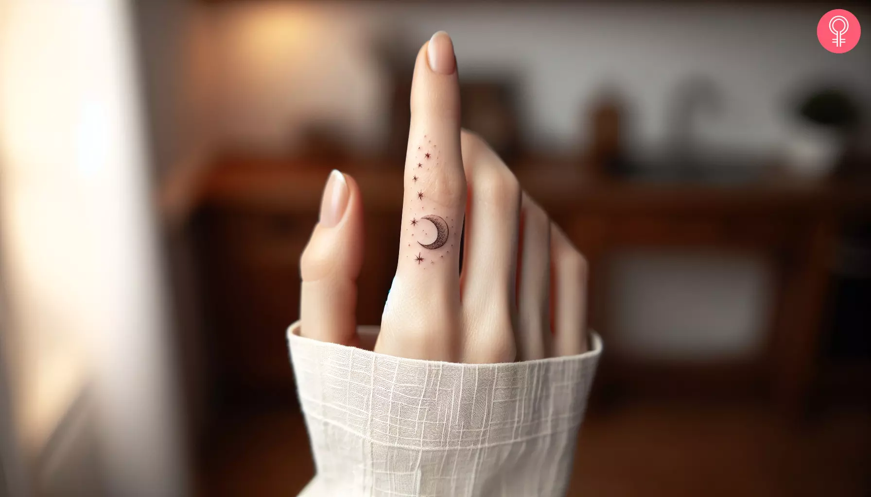 A moon and stars tattoo on the index finger