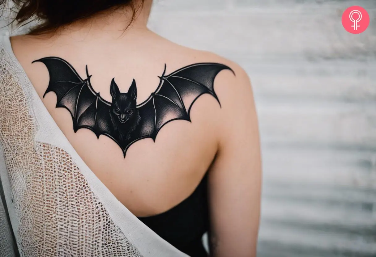 Witchy bat tattoo on the back shoulder of a woman