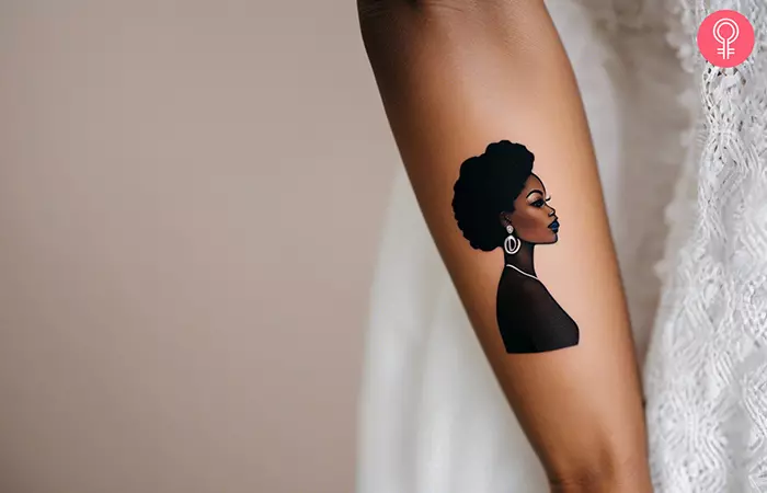 Woman with a black Barbie tattoo on her outer arm