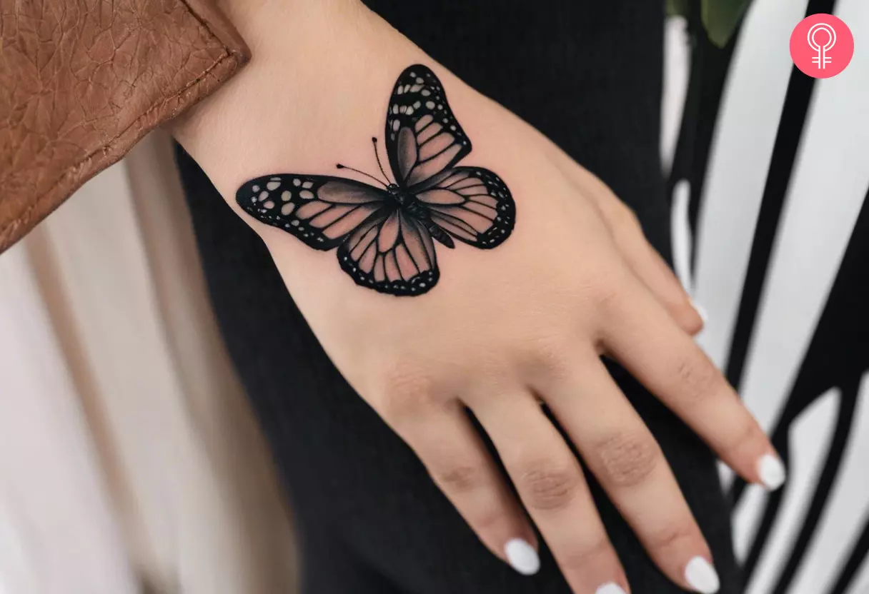 Woman with a black butterfly tattoo on her hand