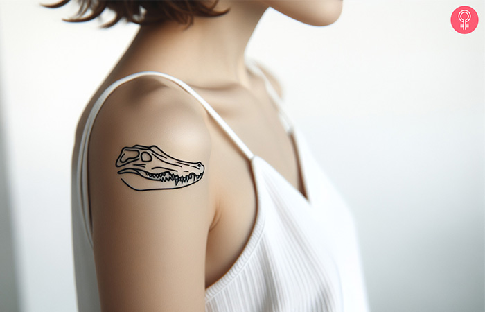 Woman with a crocodile skull tattoo on the upper arm