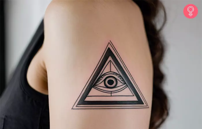 Woman with a pyramid eye tattoo on the arm