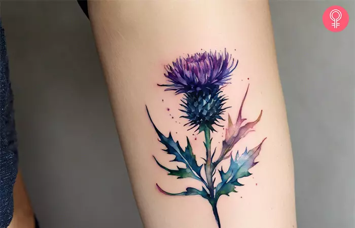 Woman with a thistle flower tattoo on the arm