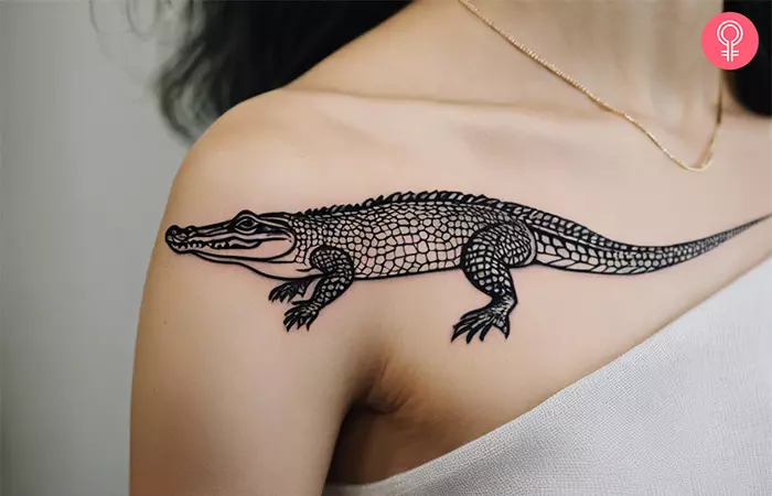 Woman with a traditional crocodile tattoo on the upper arm