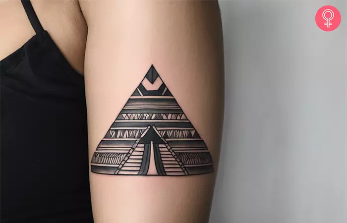 Woman with an Aztec pyramid tattoo on the upper arm