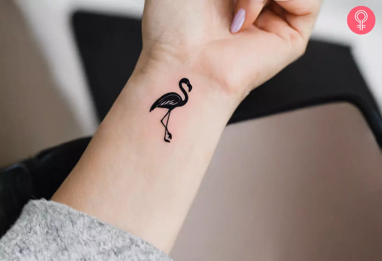 Woman with black flamingo tattoo on her wrist