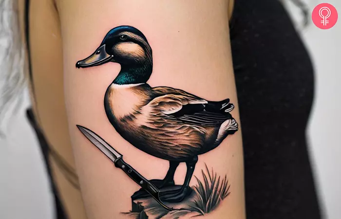 Woman with duck with knife tattoo