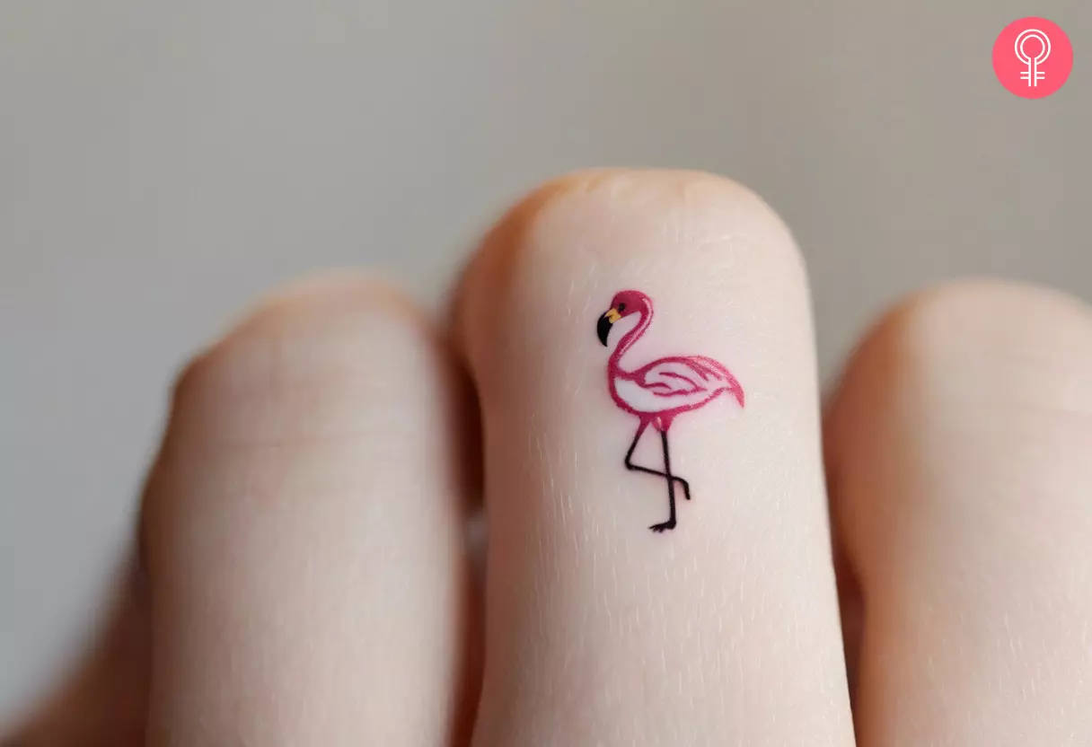 Woman with tiny flamingo tattoo on her finger