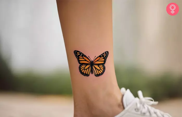 A yellow monarch butterfly tattoo on the leg