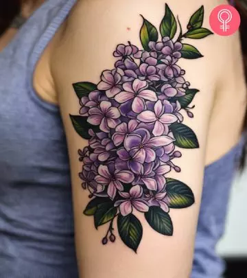 A woman wearing a violet flower tattoo on her upper arm