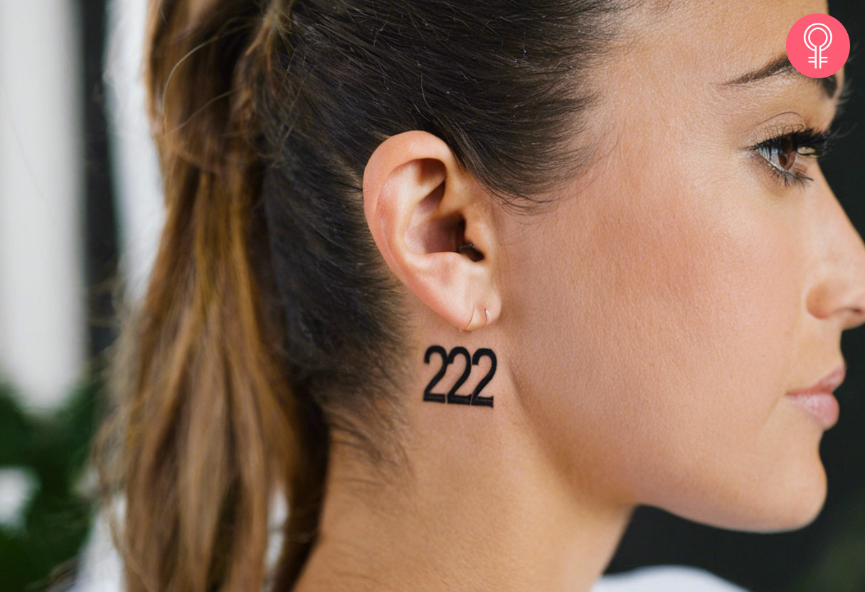 A 222 tattoo behind the ear of a woman