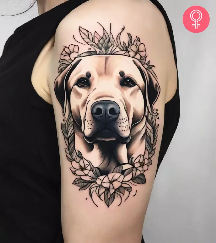 Woman with a Labrador tattoo on the upper arm