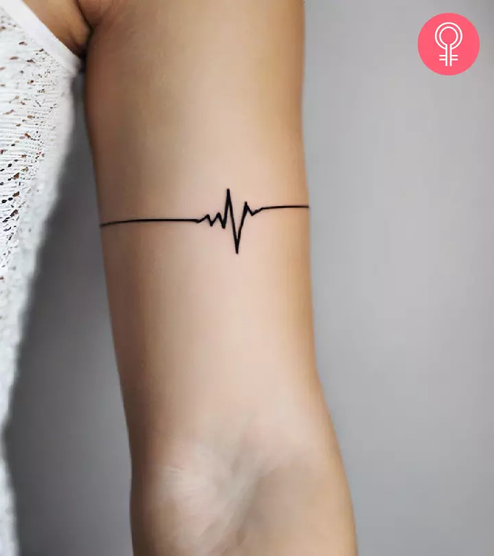 Minimalist lifeline tattoo on the upper arm of a woman
