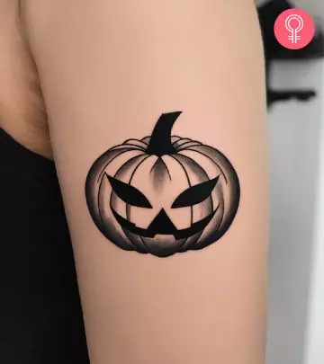 Woman with a haunted house tattoo on the upper arm