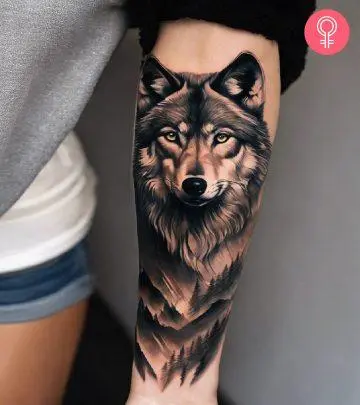 Wolf watercolor tattoo on the upper arm of a woman