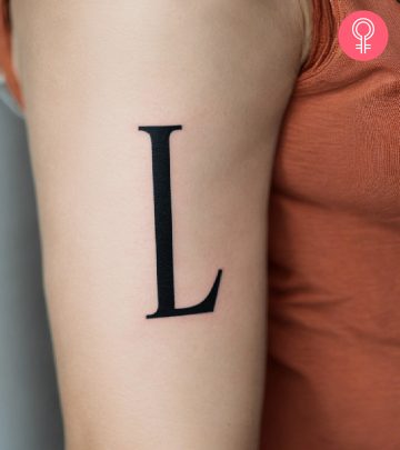 Close-up of an R tattoo design on the arm of a woman