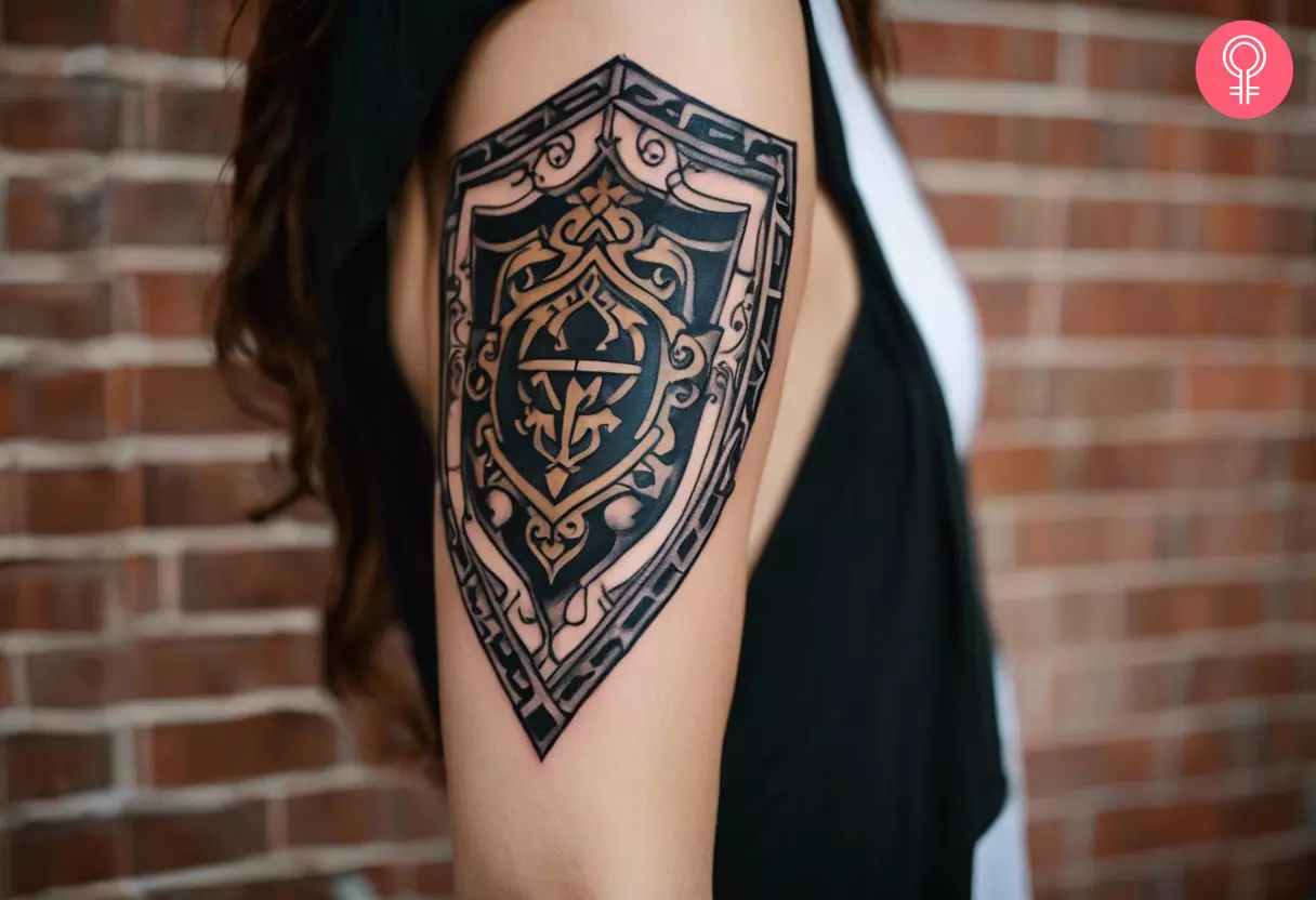Ein Hylian-Schild-Tattoo auf dem Oberarm einer Frau