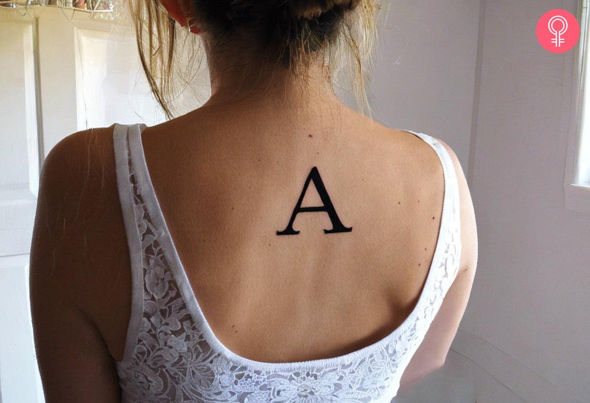 Frau mit Tattoo vom Anfangsbuchstaben „A“ auf dem oberen Rücken