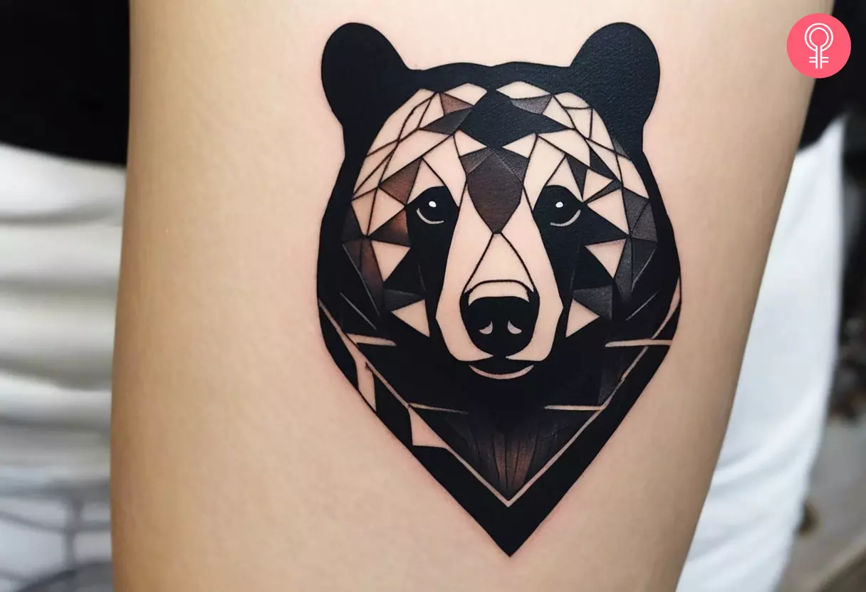 A black bear head tattoo on the forearm