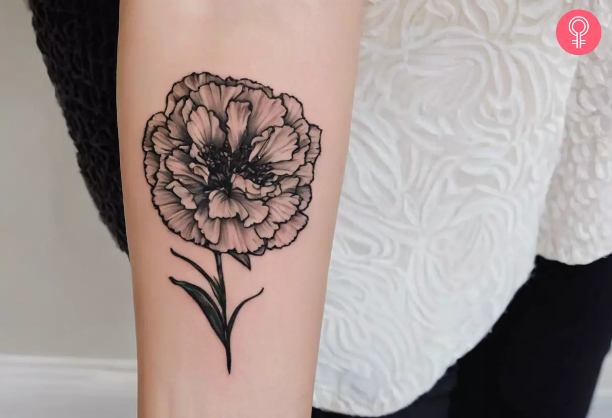 A black carnation tattoo on a woman’s forearm