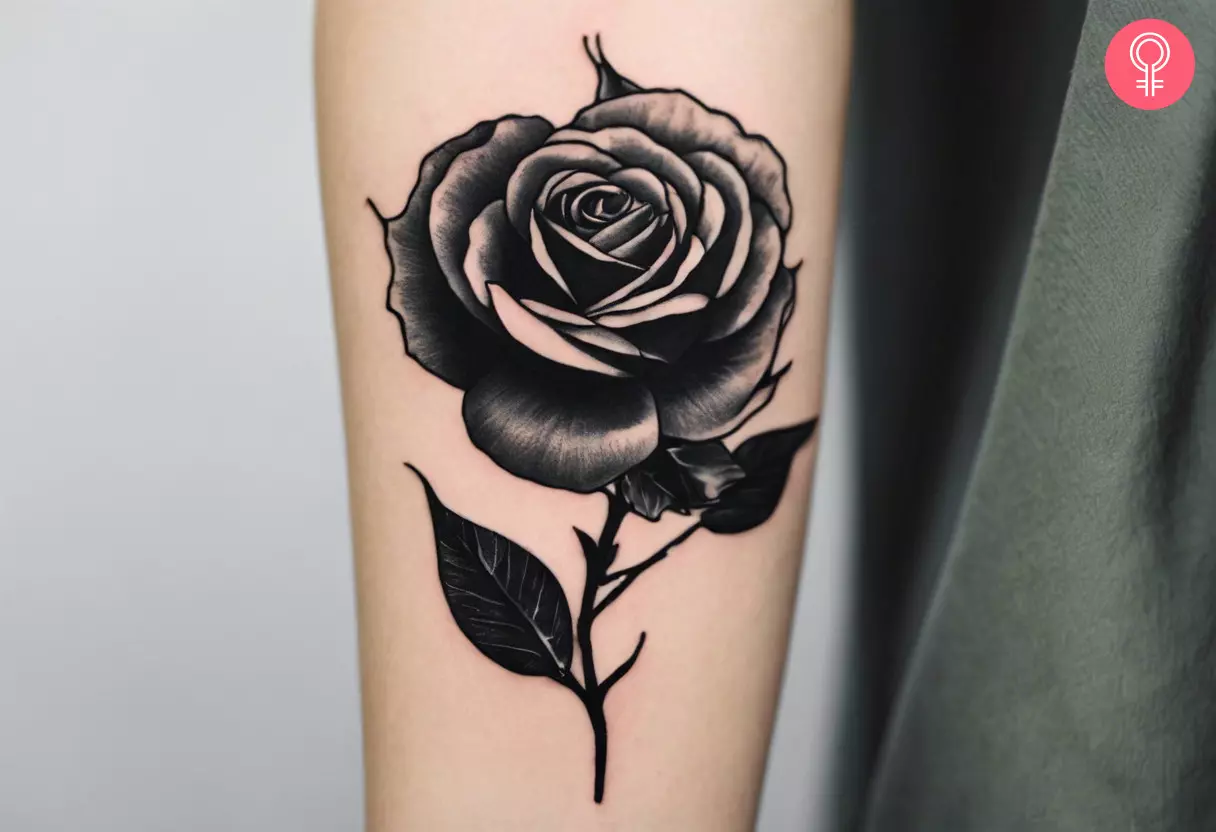 A black rose with thorns tattoo on the forearm