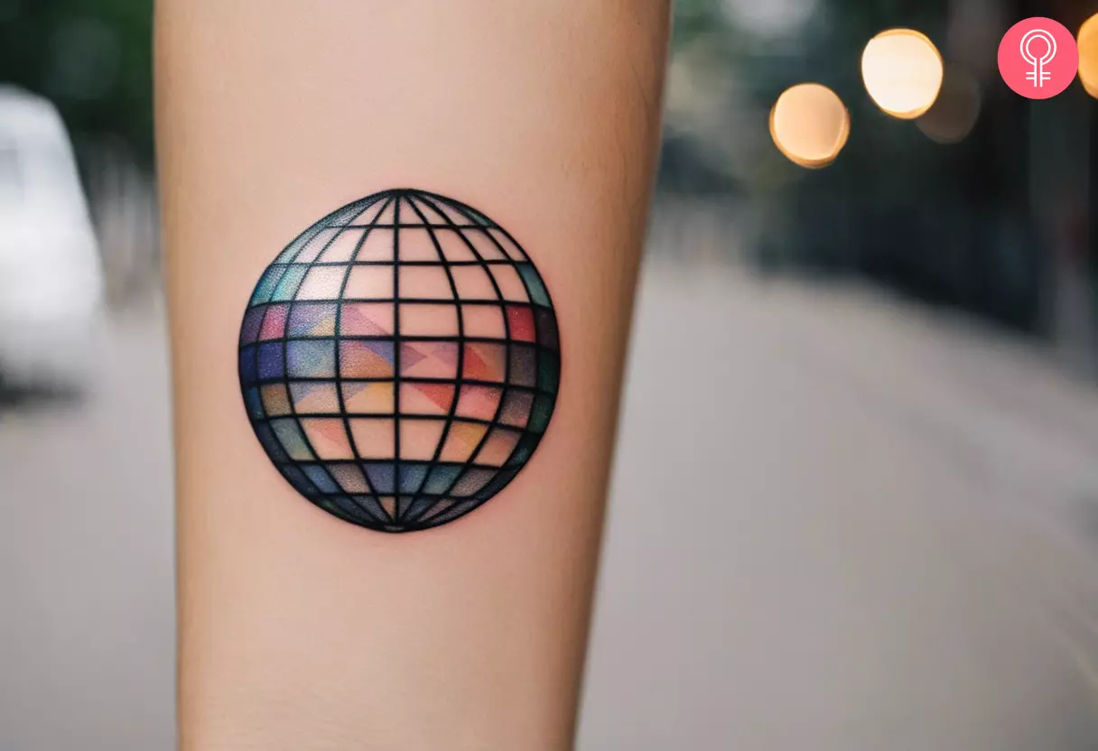 A colored disco ball tattoo on the forearm