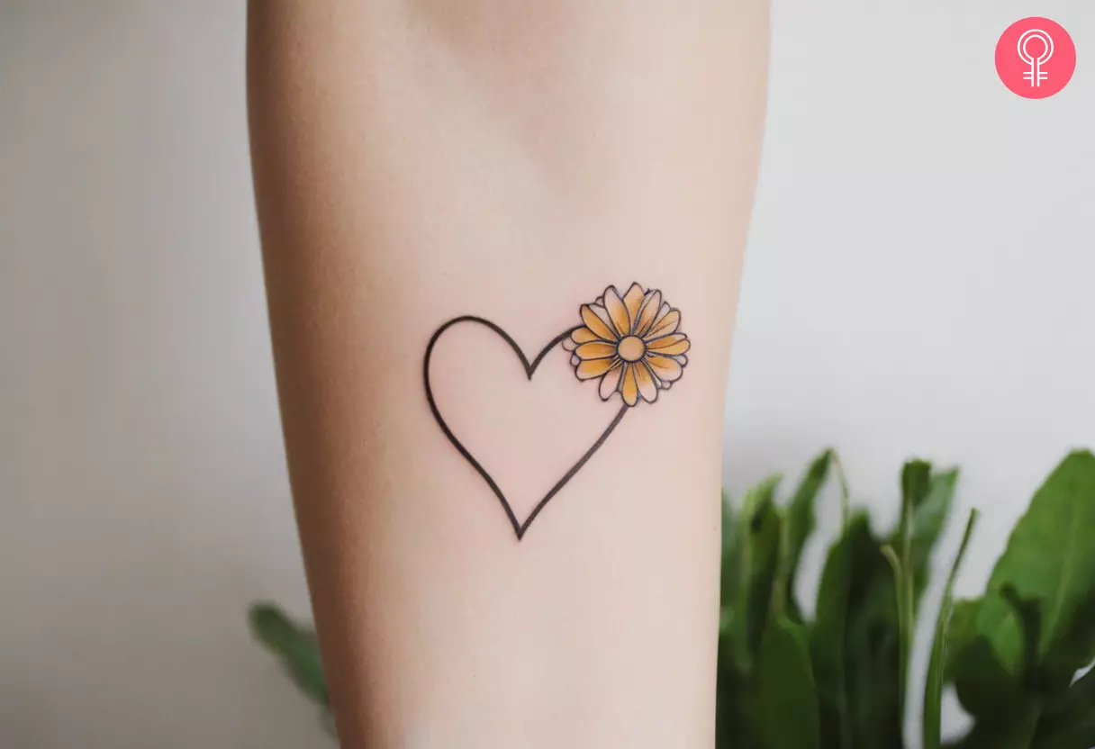 A fine line heart tattoo with a daisy flower on it