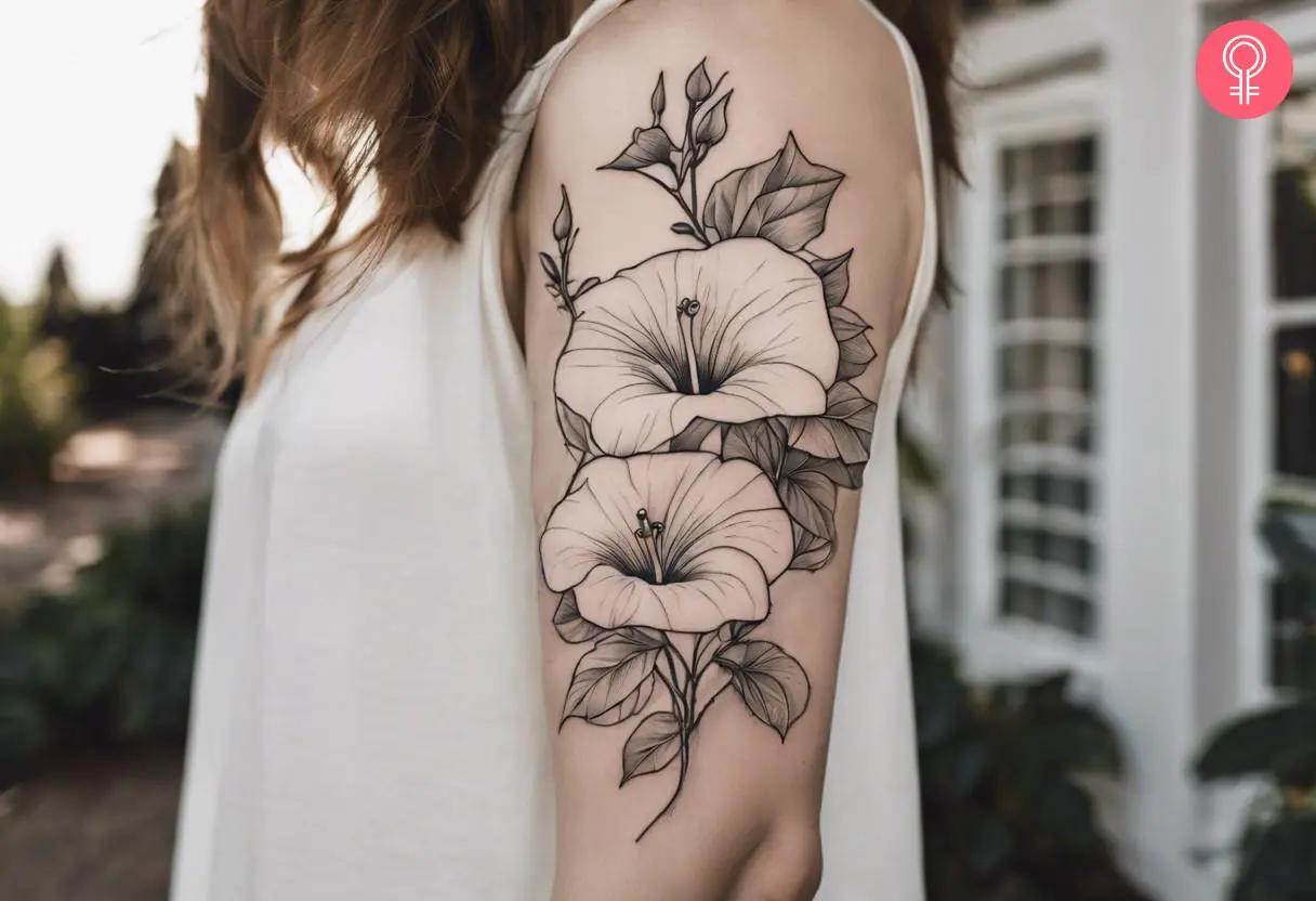 A fine-line tattoo of morning glory on a woman’s upper arm