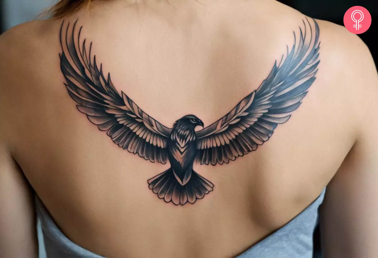 A flying hawk tattoo on the upper back