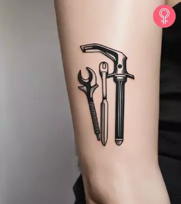 Traditional gun tattoo on the upper arm