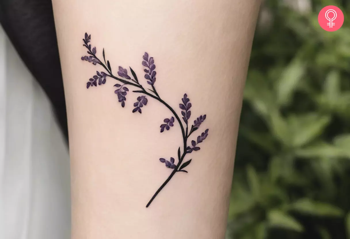 Ein minimalistisches Glyzinien-Ranken-Tattoo auf dem Arm einer Frau