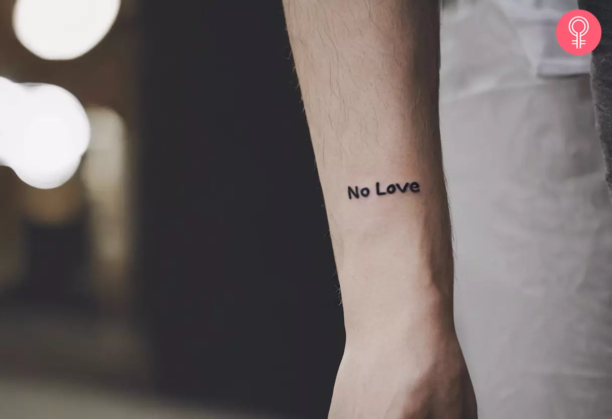 A ‘no love’ tattoo in simple font on the arm
