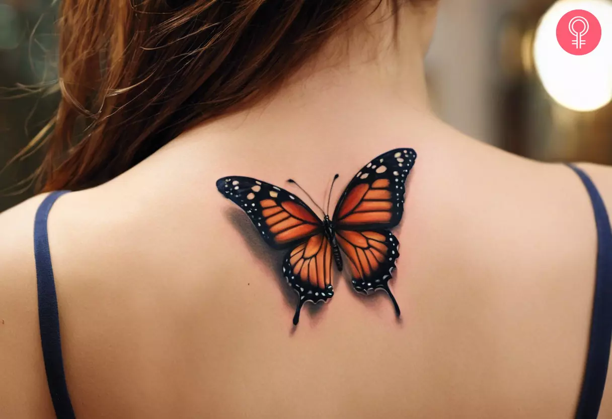 A realistic 3D butterfly tattoo on a woman’s upper back