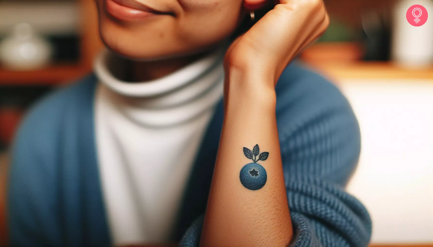 A single blueberry tattoo near the wrist of a woman