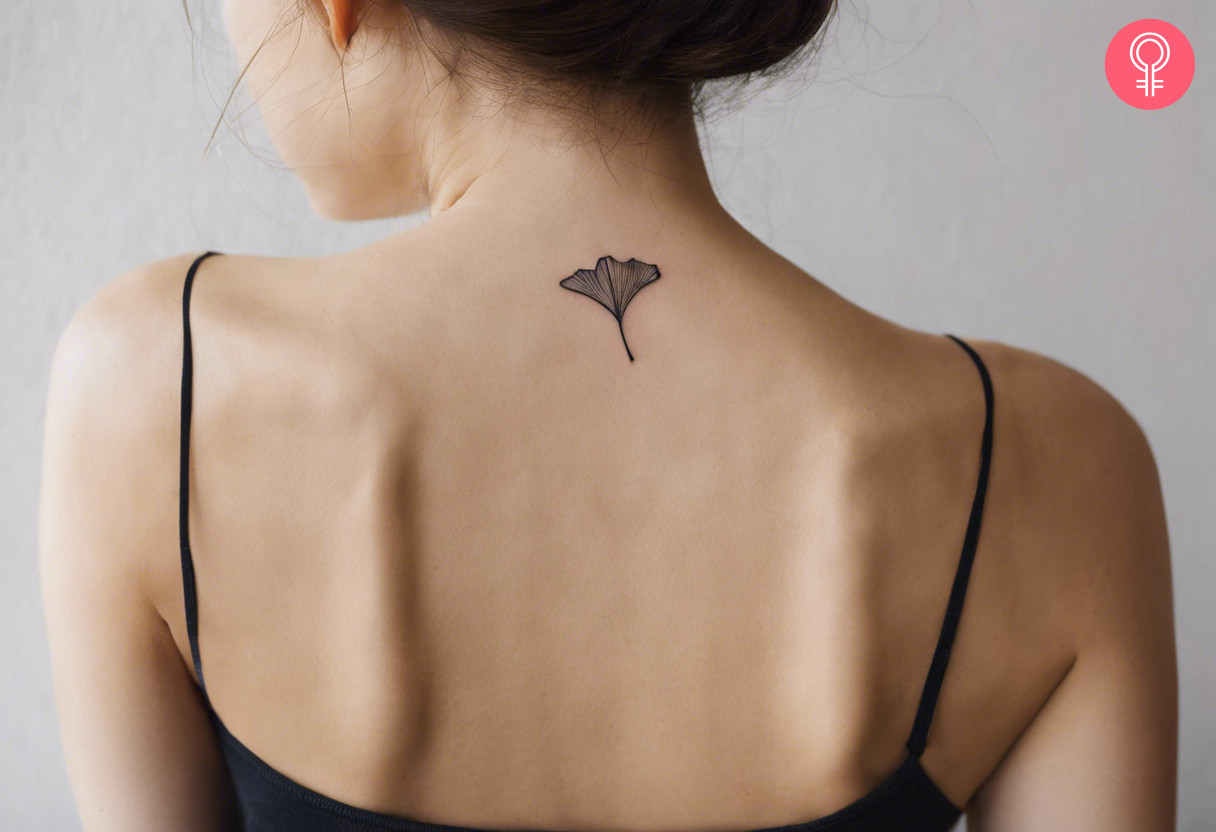 A small and simple Ginkgo leaf tattoo on the back of the neck