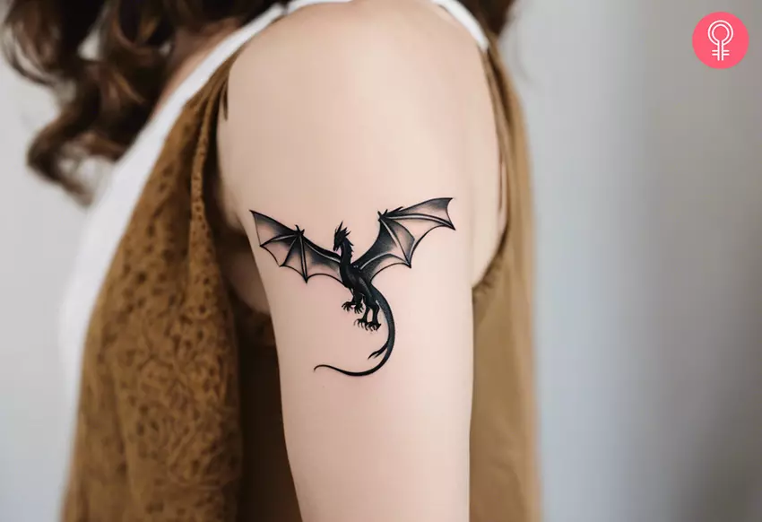 A small flying dragon tattoo on the upper arm