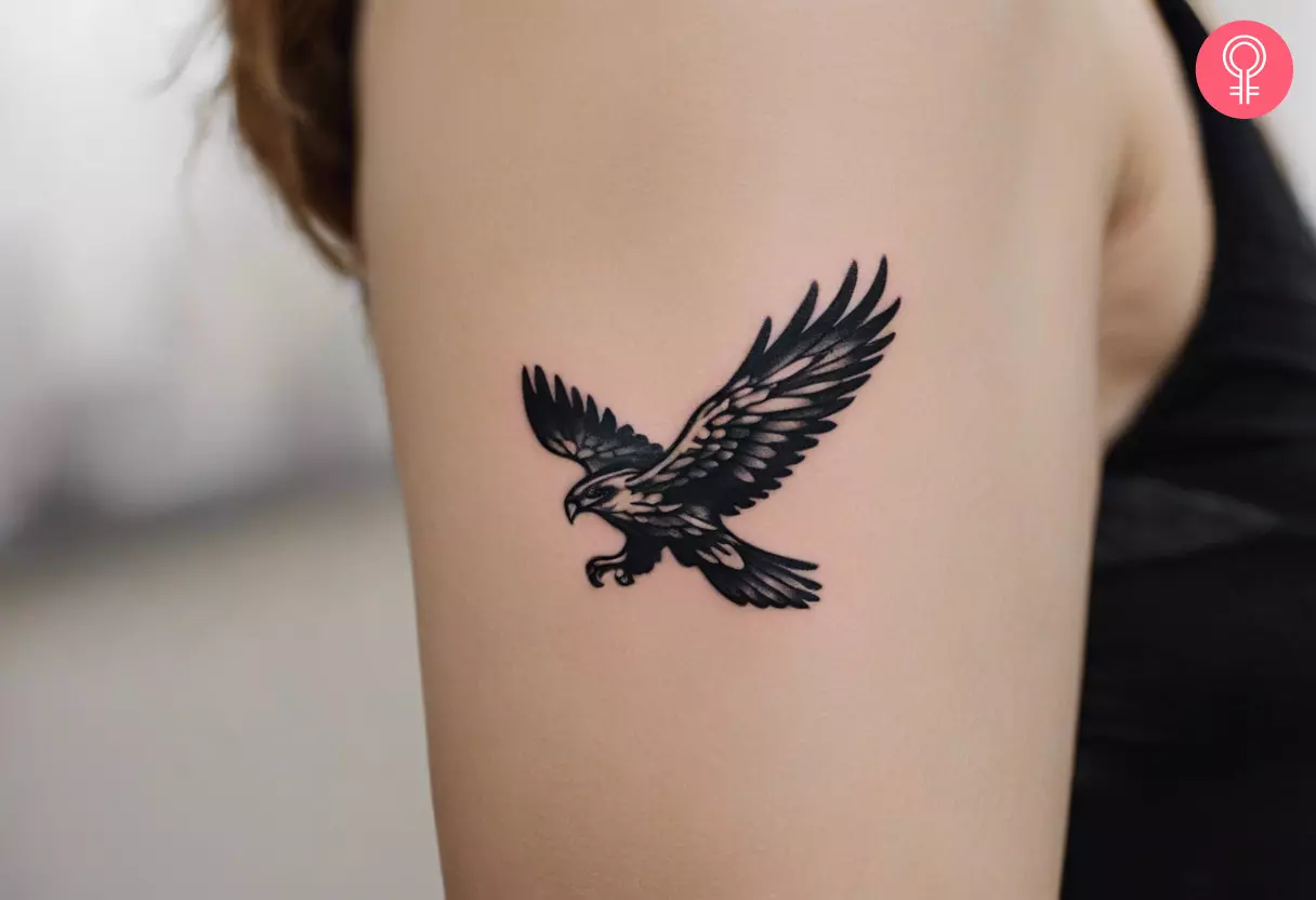 A small hawk tattoo on the upper arm