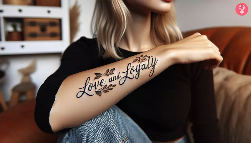 A tattoo with the words love and loyalty on the forearm