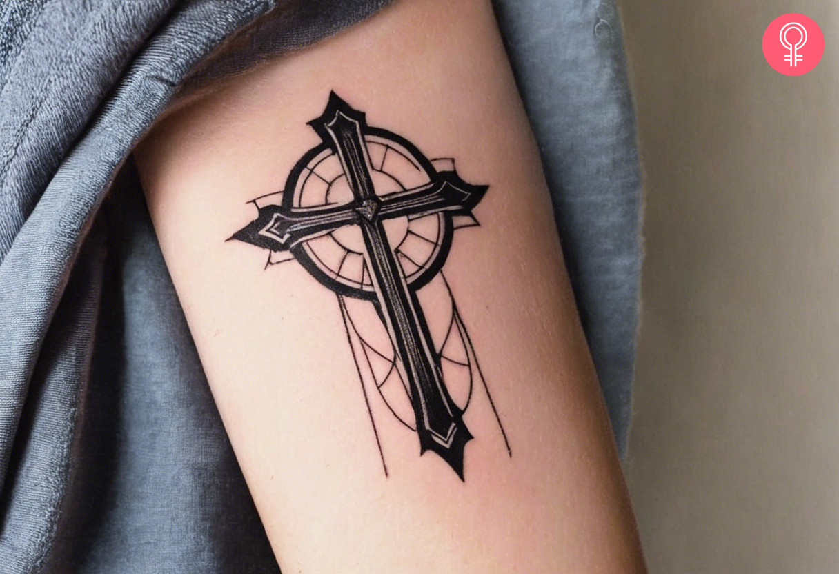 A traditional cross tattoo on the upper arm