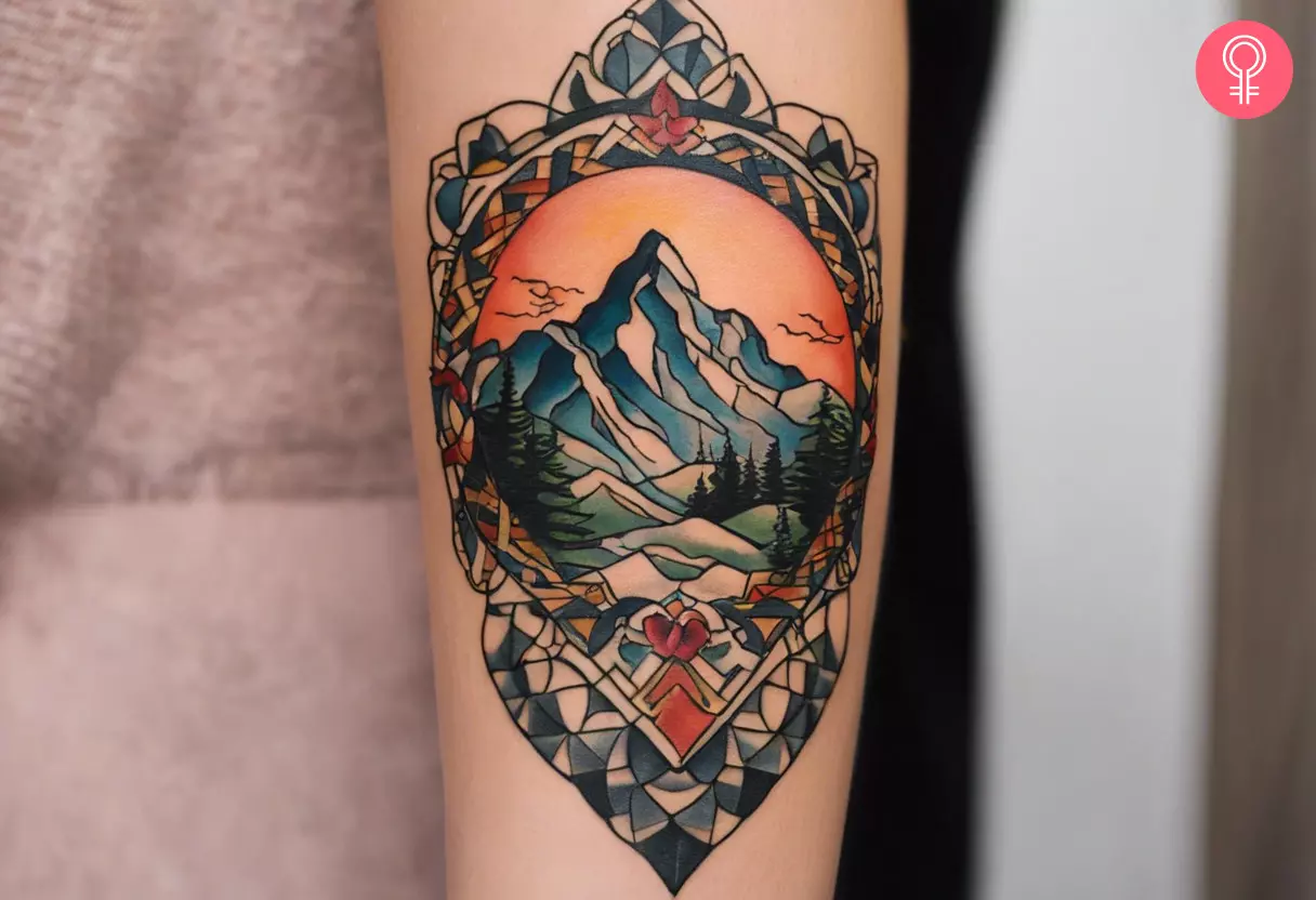 A traditional tattoo of a mountain landscape on the forearm