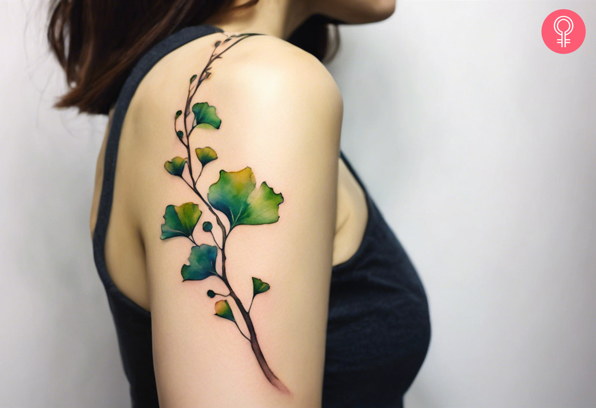 A watercolor style Ginkgo leaf tattoo covering the upper arm and shoulder