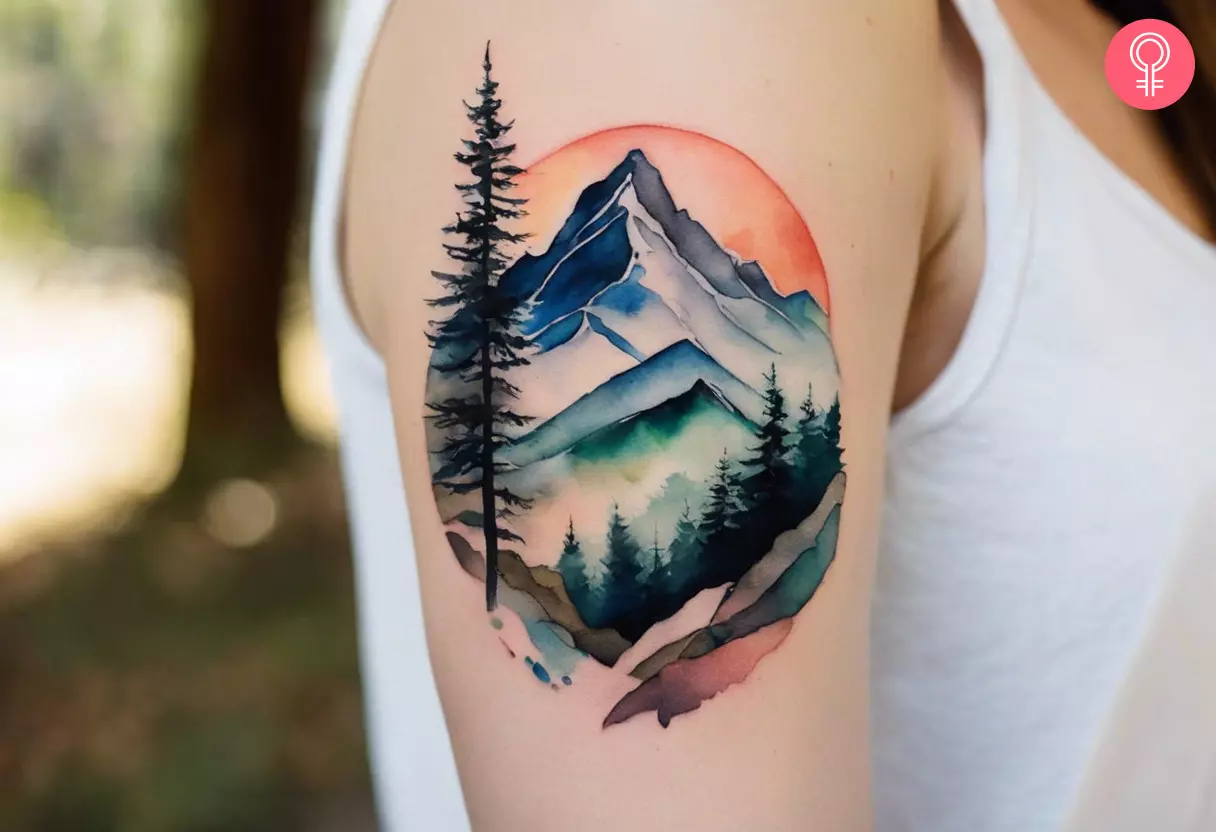 A watercolor tattoo of a mountain on the upper arm