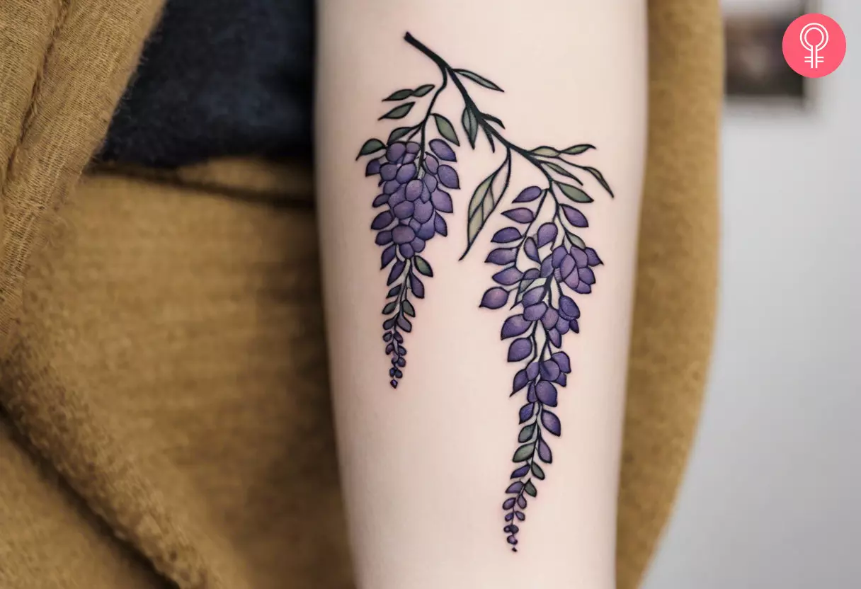 Ein Glyzinien-Blumen-Tattoo auf dem Arm einer Frau