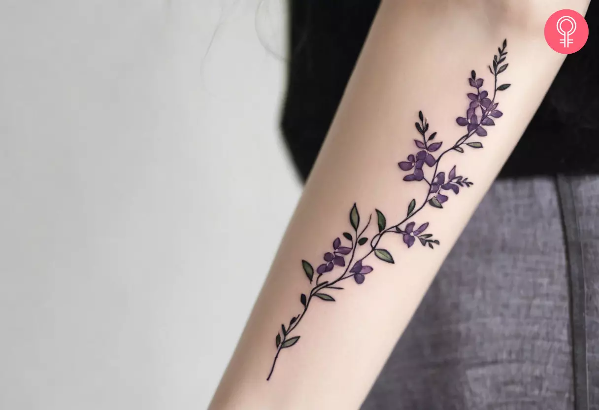 Ein Glyzinienranken-Tattoo auf dem Arm einer Frau