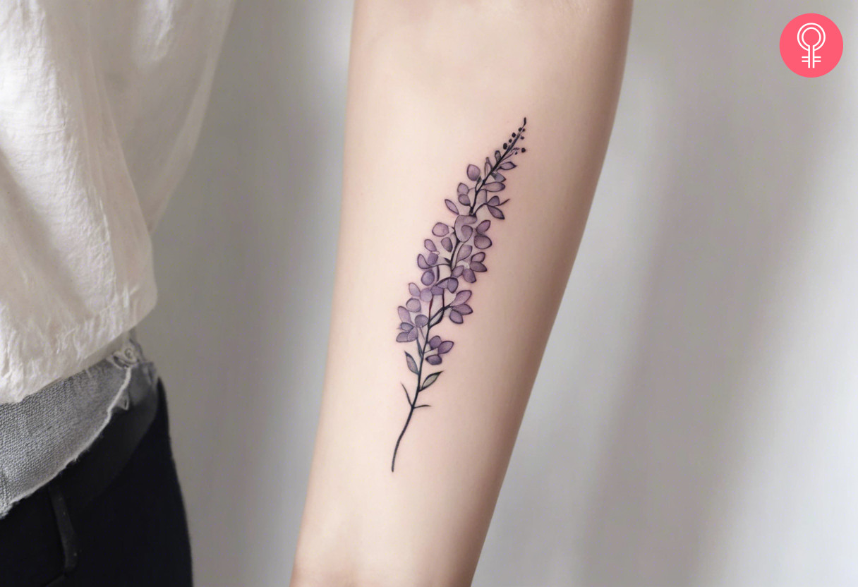 A wisteria vine tattoo on the forearm of a woman