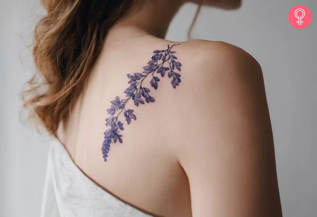 Ein Glyzinienranken-Tattoo auf der Schulter einer Frau