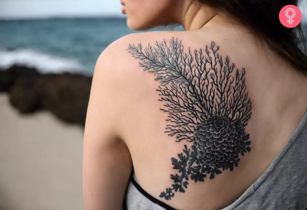 A woman with a black and gray coral reef tattoo on her upper back