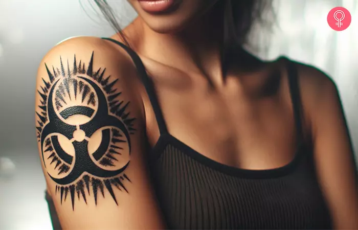 A woman with a black biohazard tattoo with spikes on her upper arm