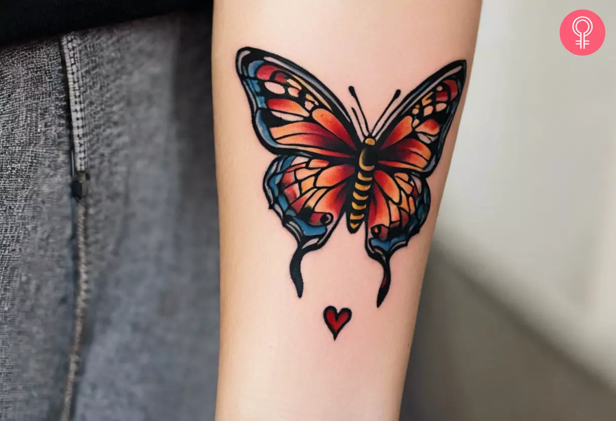 A woman with a butterfly and heart tattoo on her forearm