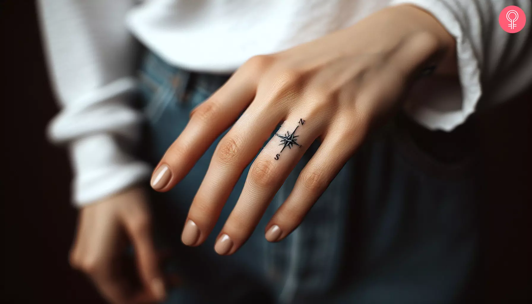 A woman with a compass finger tattoo